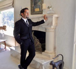 Zubin standing in front of mantel in suit